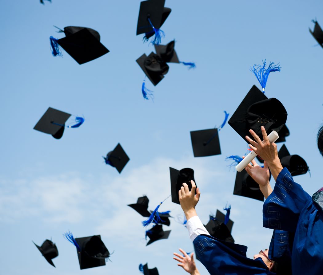 College graduation caps flying in the air to celebrate!