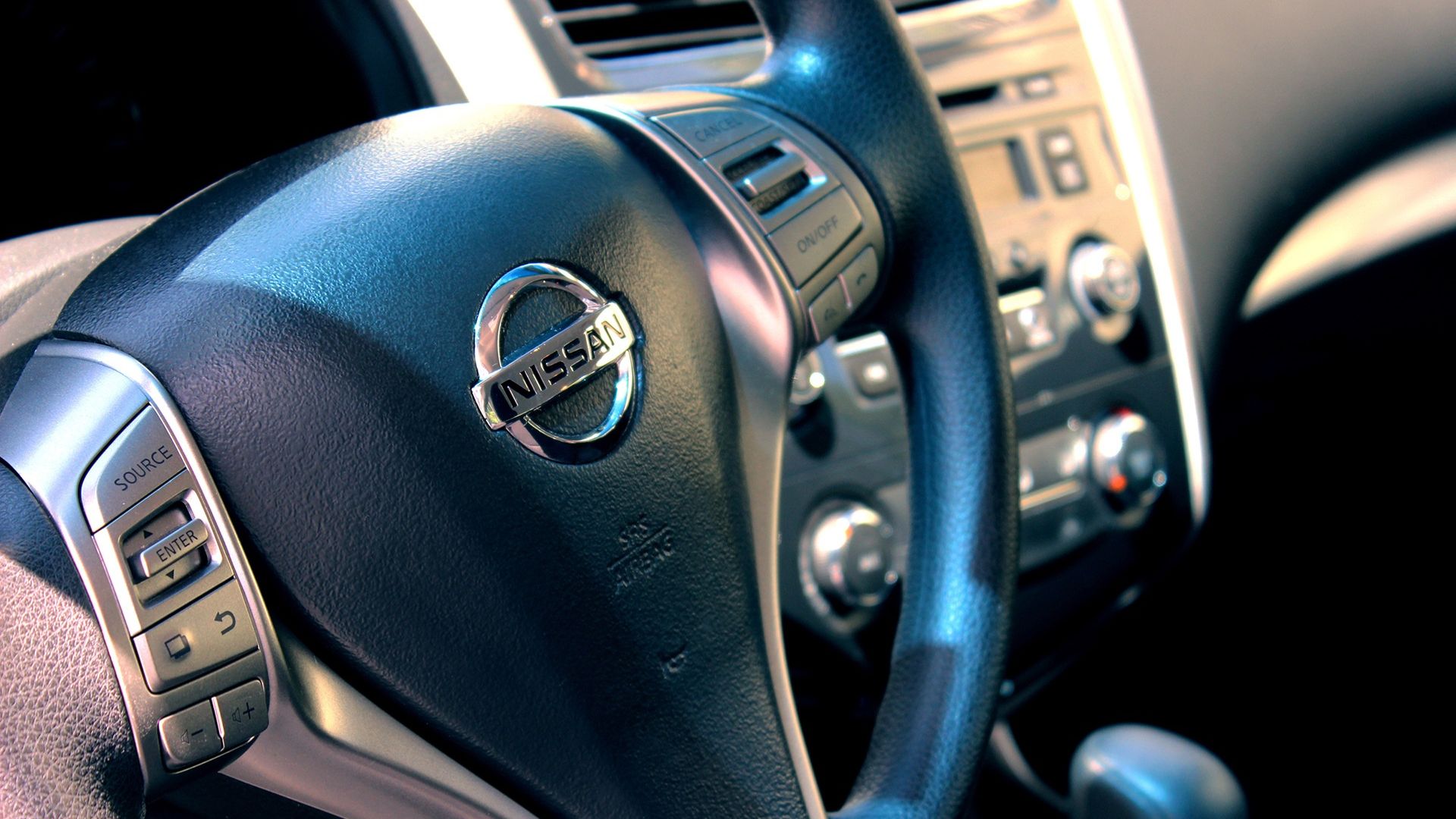 The steering wheel inside of a Nissan car. 