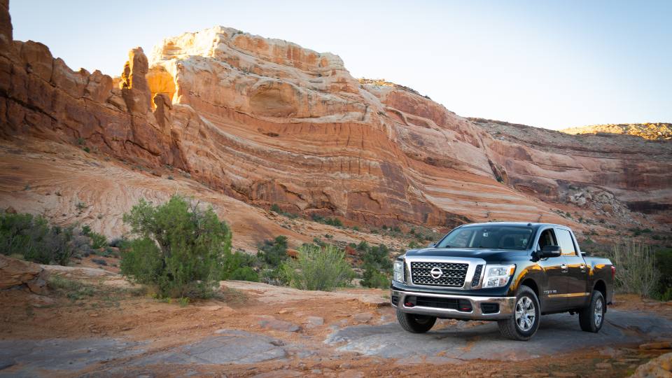 A black Nissan Titan truck in a picturesque, rugged, desert scene.