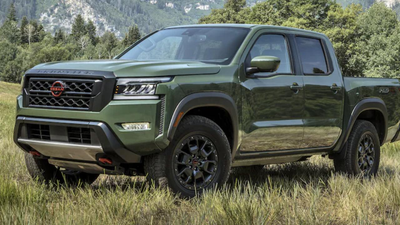 A 2022 Nissan Frontier parked in a field on a front and side view.